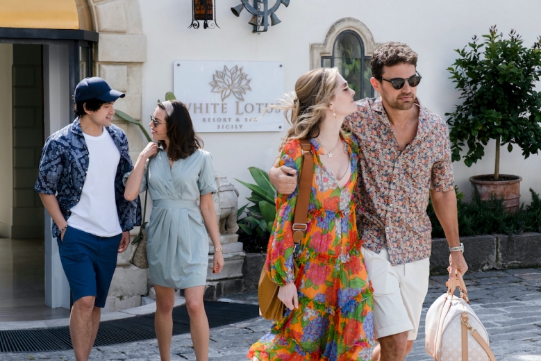 Two couples in their 30s wearing summery attire as they exit a hotel; still from The White Lotus