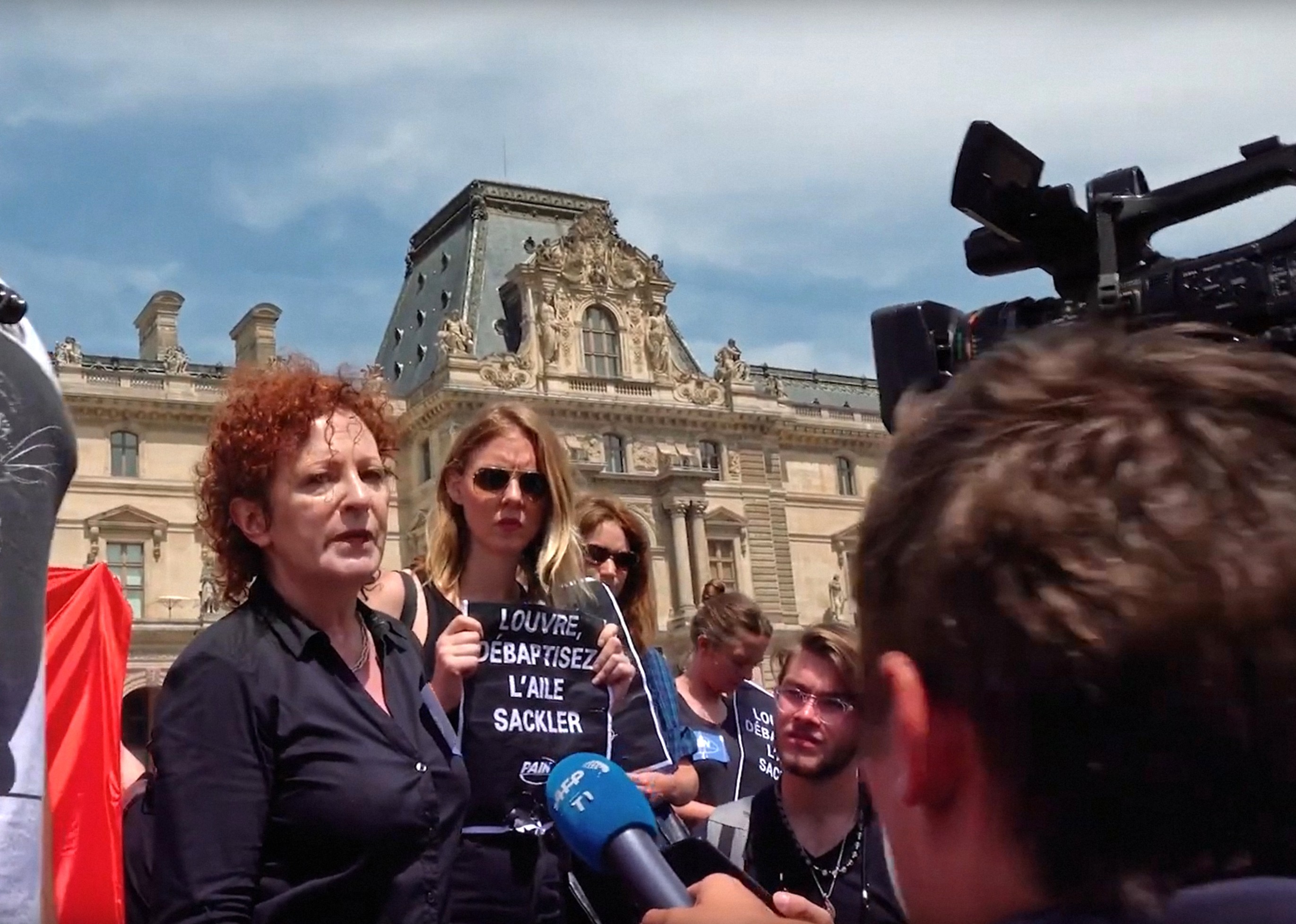 ALL THE BEAUTY AND THE BLOODSHED, Nan Goldin leading protest to remove the Sackler name from galleries at the Louvre, Paris, 2022. © Neon / courtesy Everett Collection